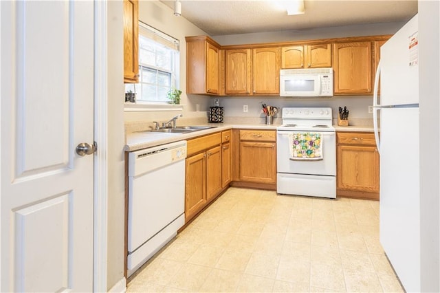 kitchen featuring a sink, brown cabinets, white appliances, and light countertops