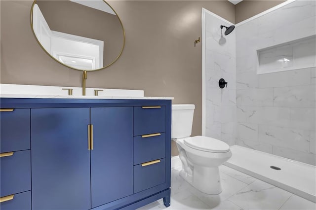 bathroom with vanity, toilet, and a tile shower