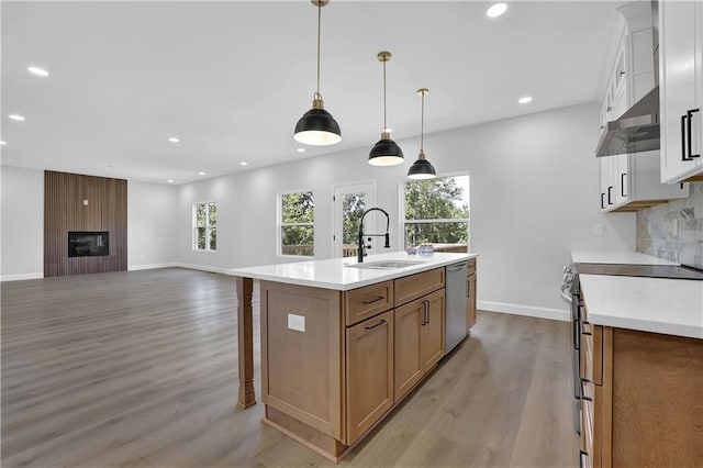 kitchen featuring stainless steel appliances, sink, a center island with sink, light hardwood / wood-style flooring, and white cabinetry