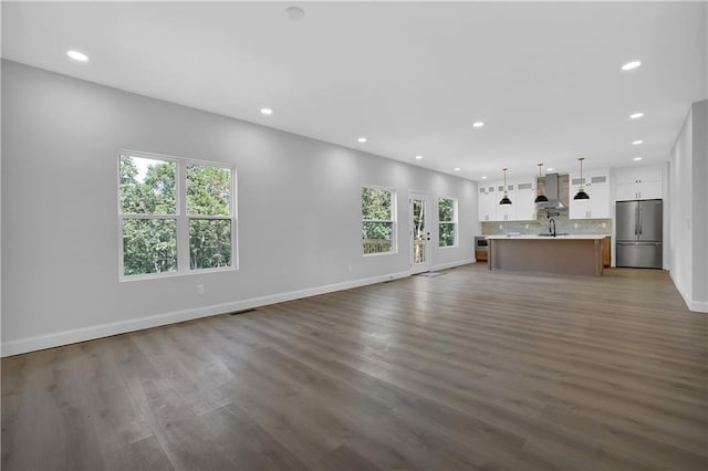 unfurnished living room featuring dark hardwood / wood-style floors and sink