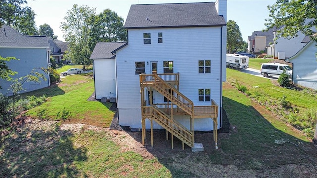 rear view of house featuring a lawn and a wooden deck