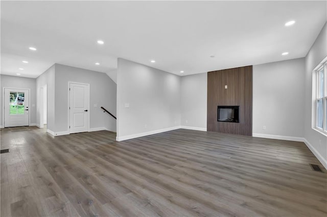 unfurnished living room featuring hardwood / wood-style floors and a large fireplace