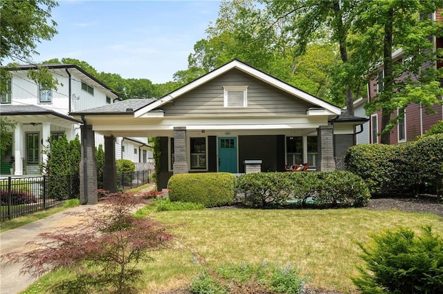 view of front of house with a porch, fence, and a front yard