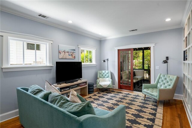 living room featuring ornamental molding, wood finished floors, and visible vents