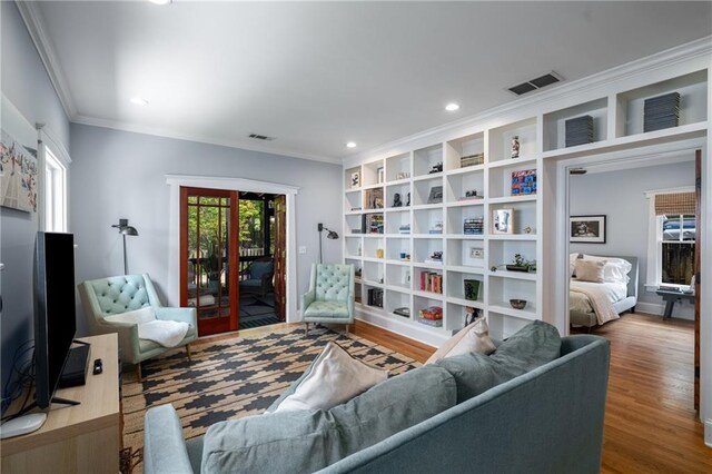 living area featuring crown molding, recessed lighting, wood finished floors, and visible vents