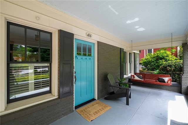 entrance to property with brick siding and covered porch