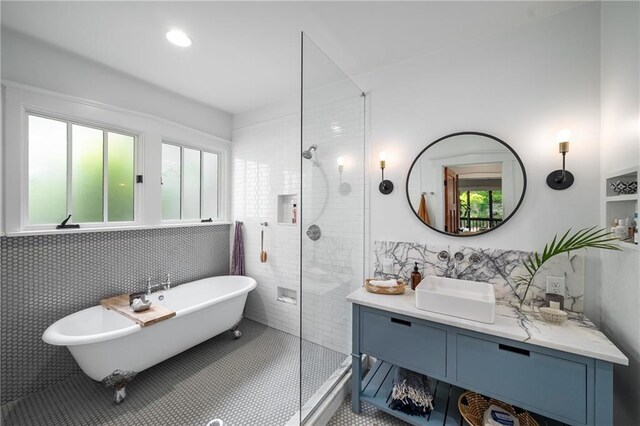 full bath with vanity, tile patterned floors, a freestanding tub, tile walls, and a stall shower