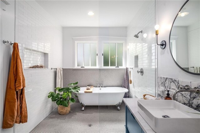 full bathroom featuring vanity, tile walls, tiled shower, tile patterned floors, and a soaking tub