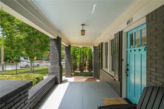 view of patio / terrace featuring fence and covered porch