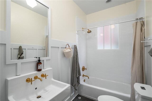 full bath with shower / bath combo with shower curtain, a sink, and toilet