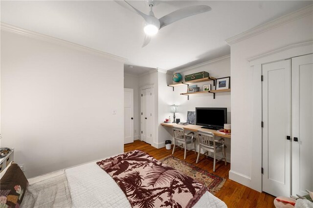bedroom with baseboards, ornamental molding, a ceiling fan, and wood finished floors