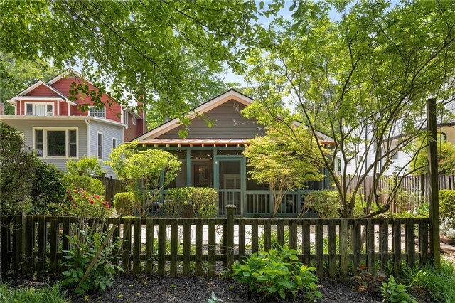 rear view of house with a sunroom and fence private yard