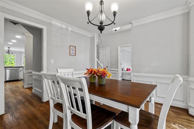 4381 Laurian Dr NW, Kennesaw, GA 30144 - dining space featuring a chandelier, a decorative wall, crown molding, dark wood-type flooring, and wainscoting