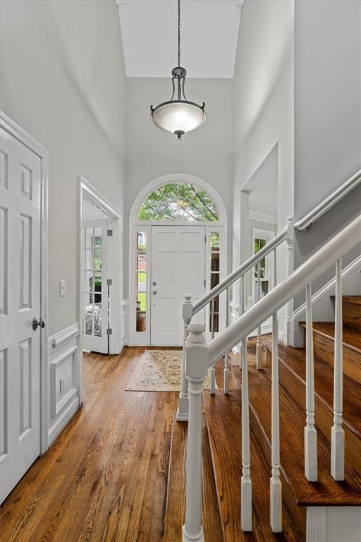 4381 Laurian Dr NW, Kennesaw, GA 30144 - foyer featuring a high ceiling, wood finished floors, stairway, and a wainscoted wall