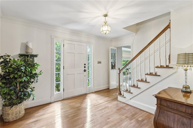 foyer entrance with plenty of natural light, wood finished floors, baseboards, and crown molding