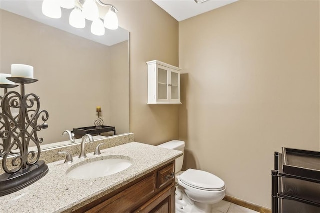 bathroom with toilet, tile patterned floors, and vanity