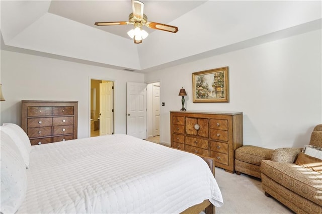 bedroom featuring light carpet, a ceiling fan, and a raised ceiling