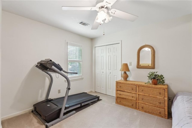 exercise room featuring light colored carpet, a ceiling fan, and baseboards