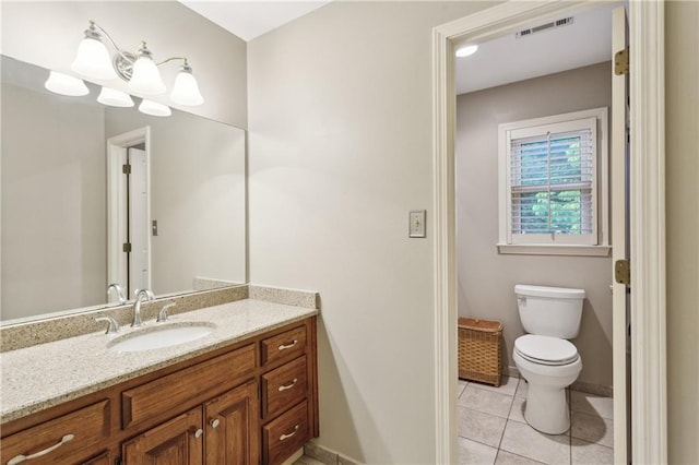 bathroom featuring tile patterned flooring, baseboards, toilet, and vanity