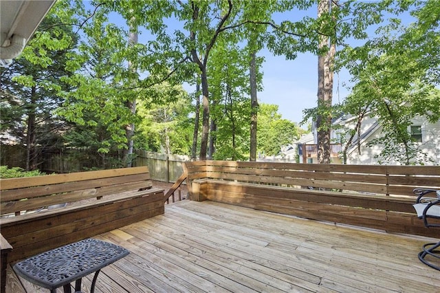 wooden terrace with a fenced backyard