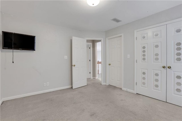 unfurnished bedroom with carpet floors, baseboards, and visible vents