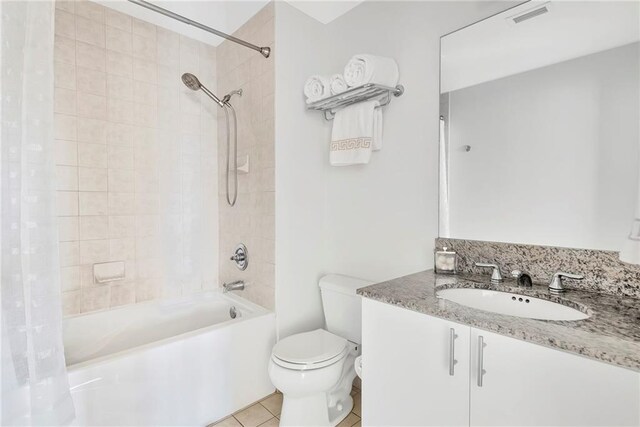 full bathroom with tile patterned floors, shower / bath combination with curtain, vanity, and toilet