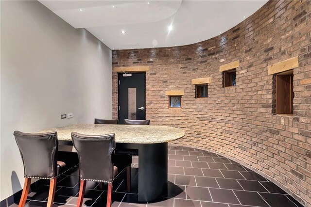 interior space featuring light stone counters and brick wall