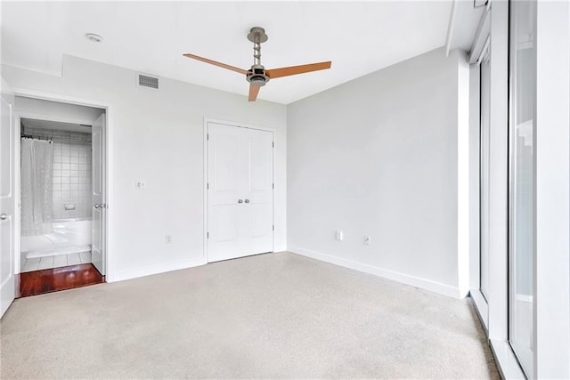 unfurnished bedroom featuring ceiling fan, connected bathroom, and light colored carpet