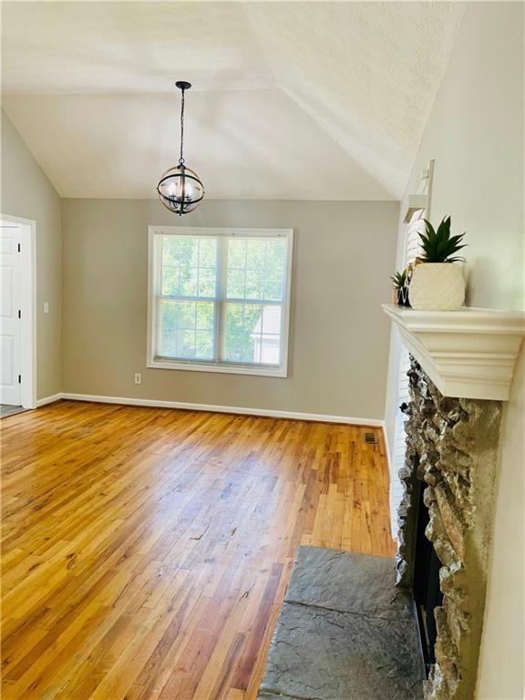 350 Fall View Ct, Winder, GA 30680 - living room featuring lofted ceiling, wood-type flooring, baseboards, a chandelier, and a fireplace