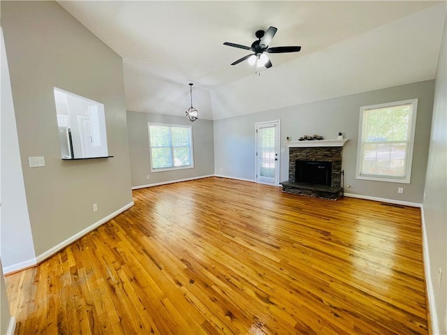 350 Fall View Ct, Winder, GA 30680 - unfurnished living room with hardwood / wood-style flooring, baseboards, vaulted ceiling, ceiling fan, and a stone fireplace