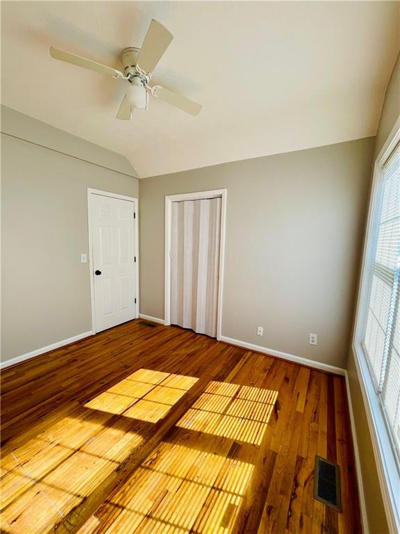 350 Fall View Ct, Winder, GA 30680 - unfurnished bedroom featuring vaulted ceiling, wood finished floors, baseboards, and a closet