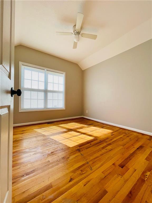 350 Fall View Ct, Winder, GA 30680 - spare room featuring lofted ceiling, hardwood / wood-style floors, baseboards, and ceiling fan