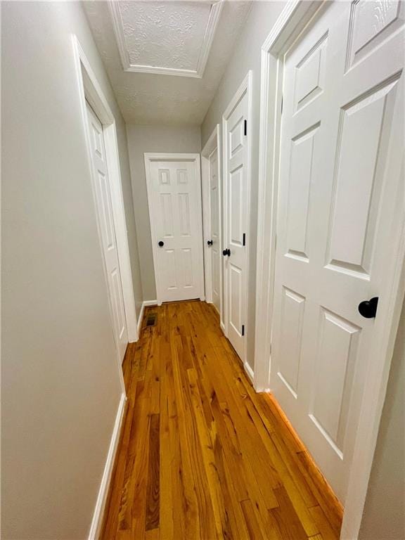 350 Fall View Ct, Winder, GA 30680 - hall with wood finished floors, baseboards, attic access, and a textured ceiling