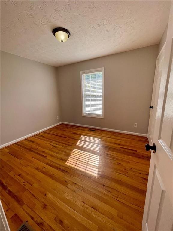 350 Fall View Ct, Winder, GA 30680 - spare room featuring wood finished floors, baseboards, and a textured ceiling