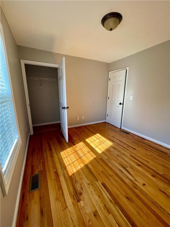350 Fall View Ct, Winder, GA 30680 - unfurnished bedroom with hardwood / wood-style floors, baseboards, and a closet