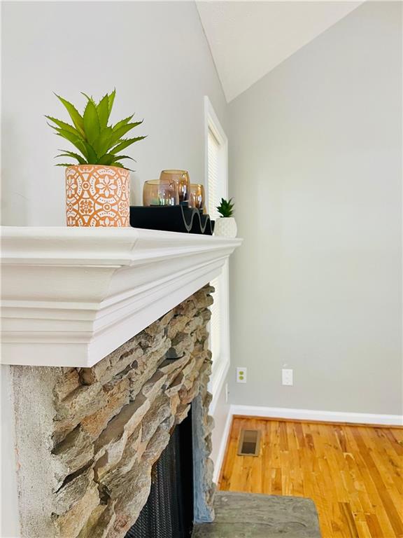 350 Fall View Ct, Winder, GA 30680 - detailed view of a stone fireplace, wood finished floors, and baseboards
