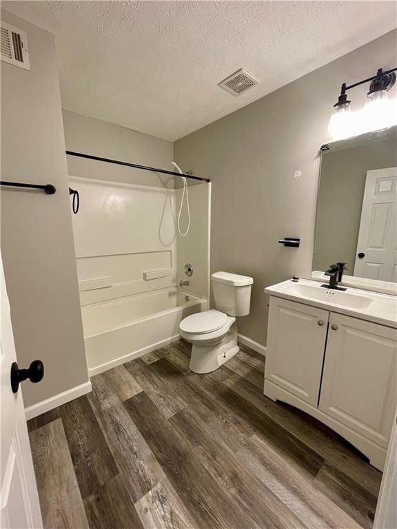 350 Fall View Ct, Winder, GA 30680 - bathroom featuring washtub / shower combination, vanity, toilet, wood finished floors, and a textured ceiling