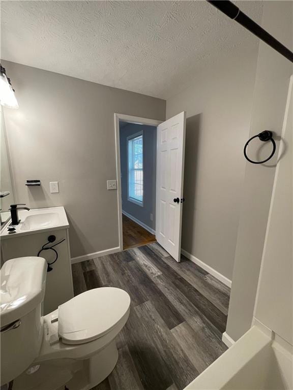 350 Fall View Ct, Winder, GA 30680 - bathroom with toilet, wood finished floors, a textured ceiling, vanity, and baseboards