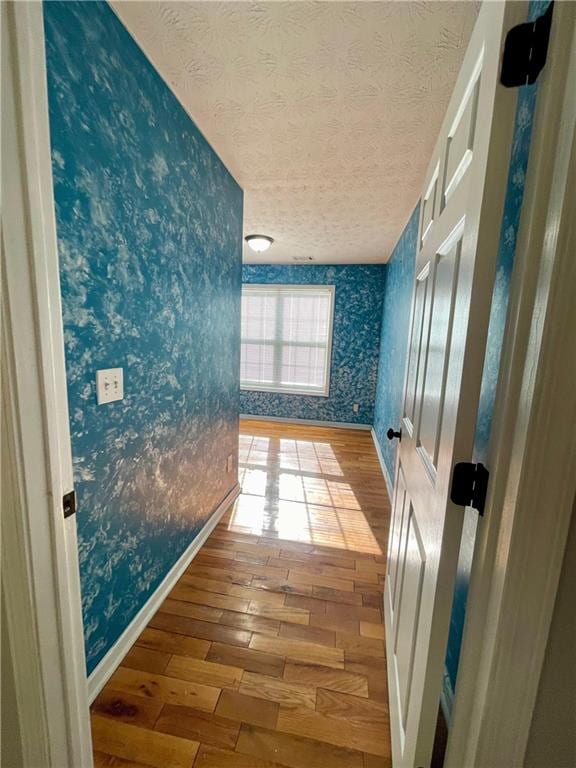 350 Fall View Ct, Winder, GA 30680 - hallway with wallpapered walls, hardwood / wood-style flooring, a textured ceiling, and baseboards