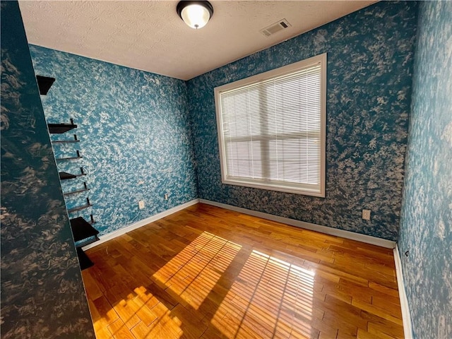 350 Fall View Ct, Winder, GA 30680 - empty room with hardwood / wood-style flooring, wallpapered walls, baseboards, and a textured ceiling