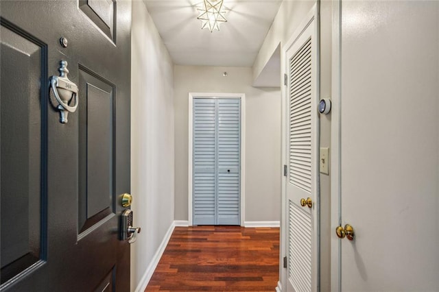 doorway to outside featuring dark wood-style flooring and baseboards