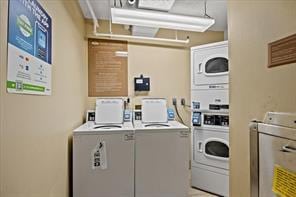 common laundry area featuring stacked washer / dryer and washing machine and clothes dryer