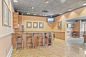 interior space with a drop ceiling and baseboards