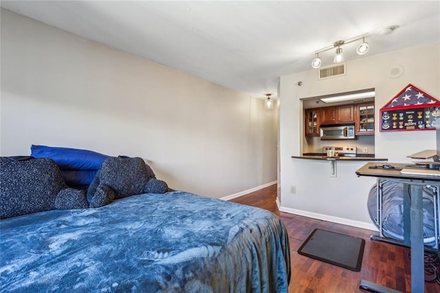 bedroom featuring wood finished floors, visible vents, and baseboards