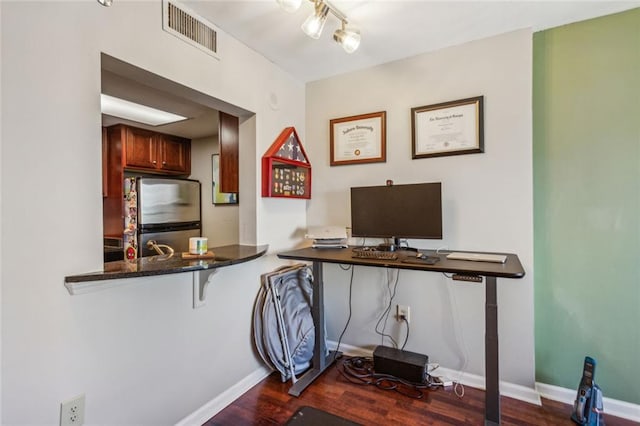 office space with dark wood-type flooring, visible vents, and baseboards