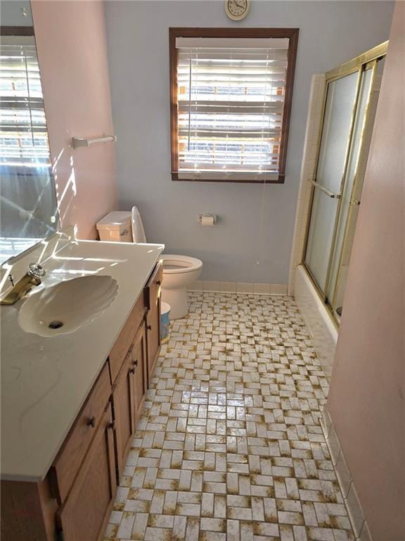 full bathroom with vanity, combined bath / shower with glass door, and toilet