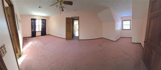 additional living space featuring light carpet, a textured ceiling, ceiling fan, and lofted ceiling