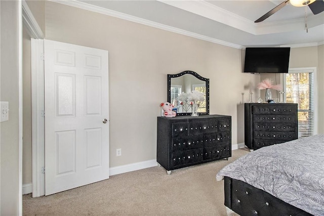 bedroom featuring a raised ceiling, carpet floors, crown molding, baseboards, and ceiling fan