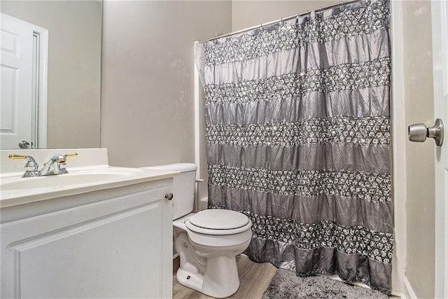 full bath with a shower with curtain, toilet, and vanity