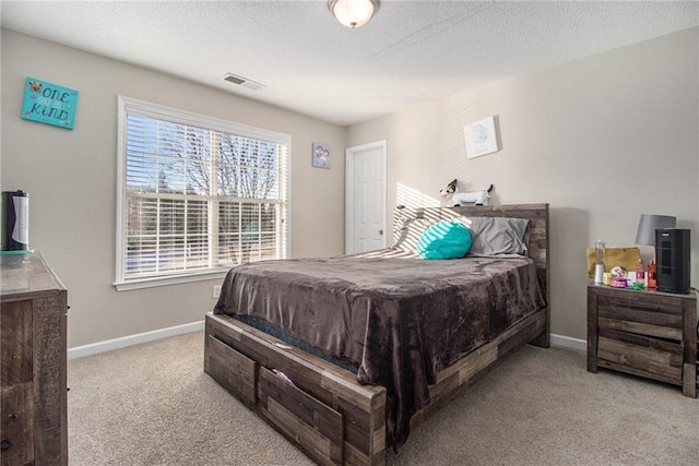 bedroom featuring baseboards, visible vents, carpet floors, and a textured ceiling